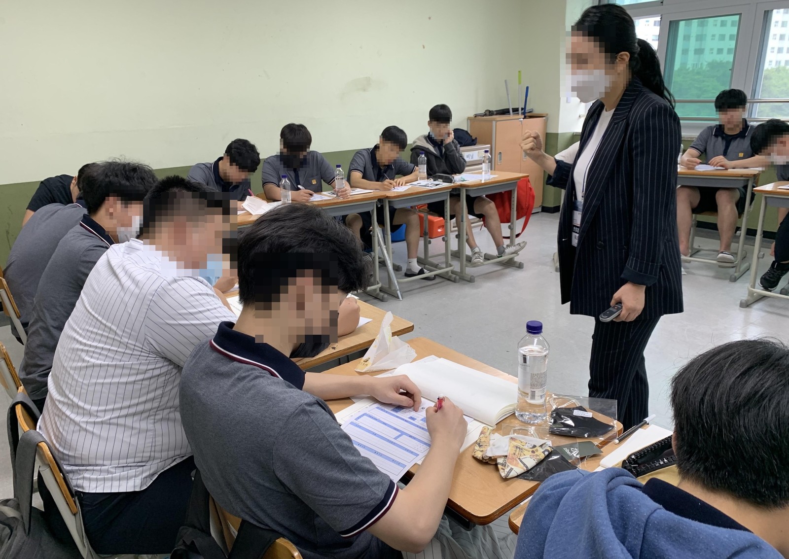 강사가 교실을 돌며 학생들의 필기를 살피는 진로 직업 강의 장면