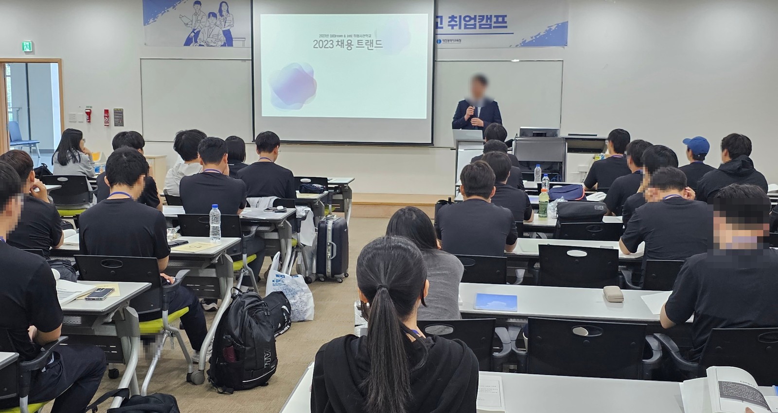 강의를 듣는 학생들을 교실 뒤에서 본 장면